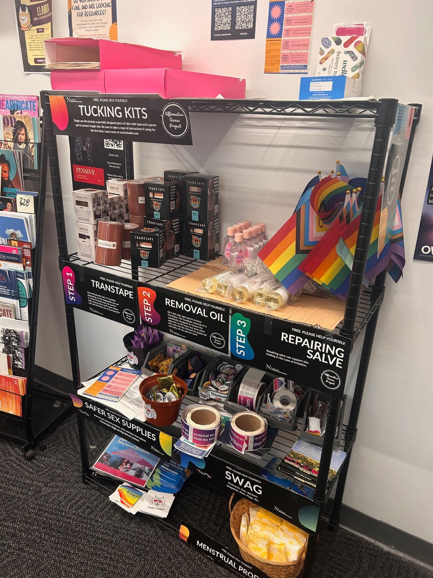 Picture of our Affirmation Access Project shelves, stocked with affirming products, stickers, pins, and more.